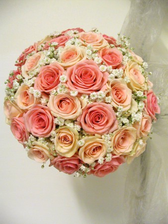 Söt kompakt bukett i hållare med 2 nyanser rosa och brudslöja mellan 